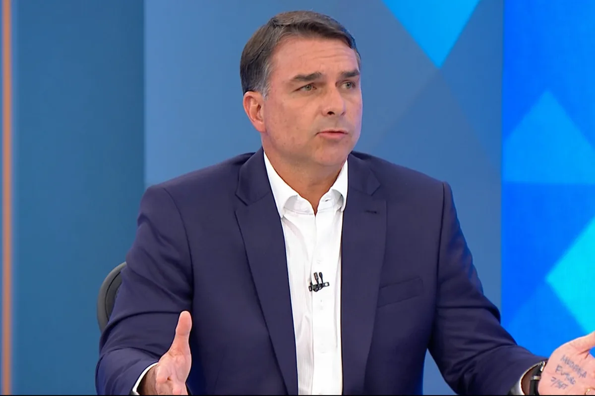 Flávio Bolsonaro leva “cola” na mão no JN. Saiba o que estava escrito