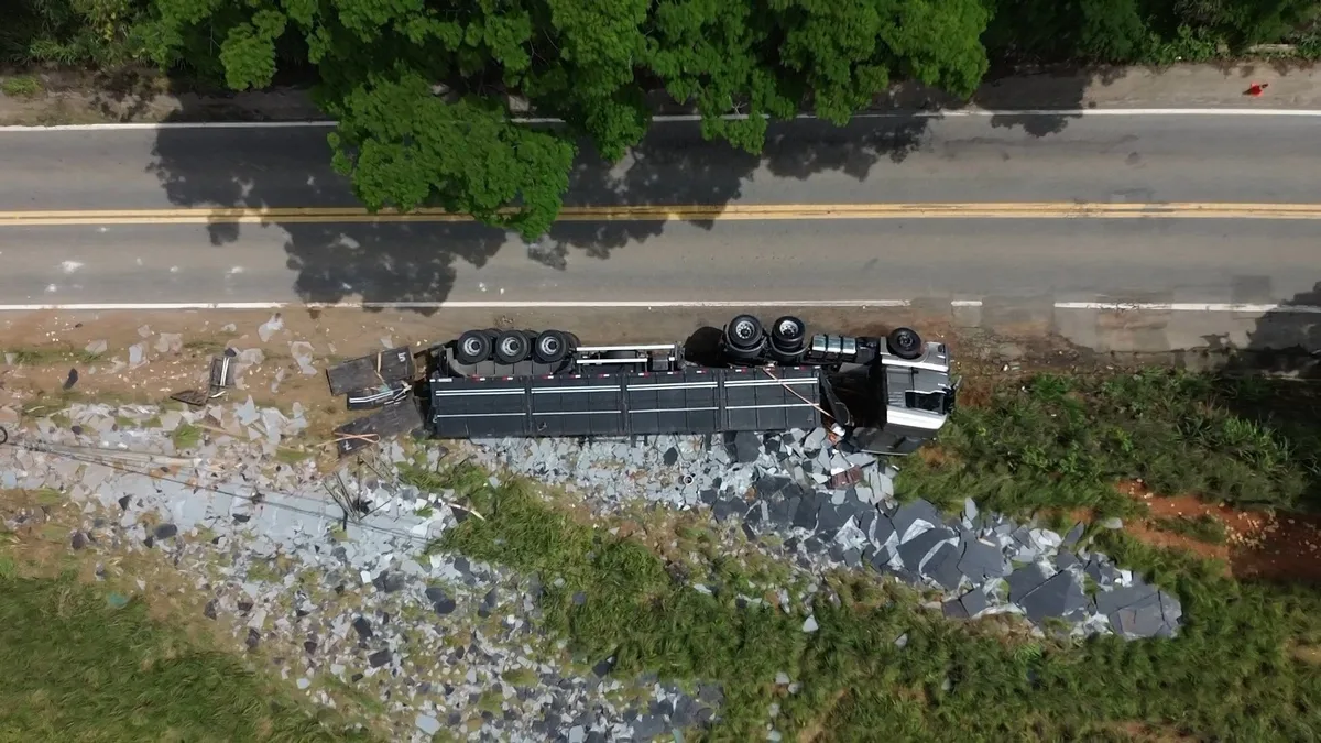 Carreta com mármore tomba, deixa motorista ferido e poste cai sobre outro caminhão no ES