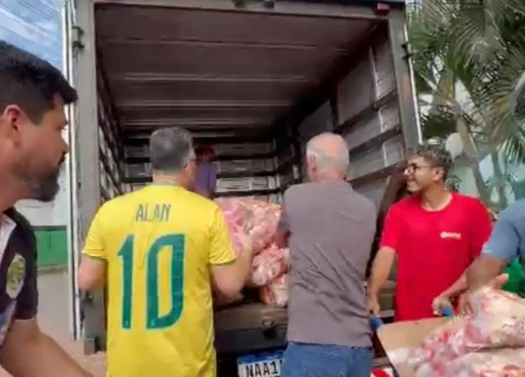 Durante caminhada na Baixada, Alan Rick ajuda trabalhadores a carregar caminhão