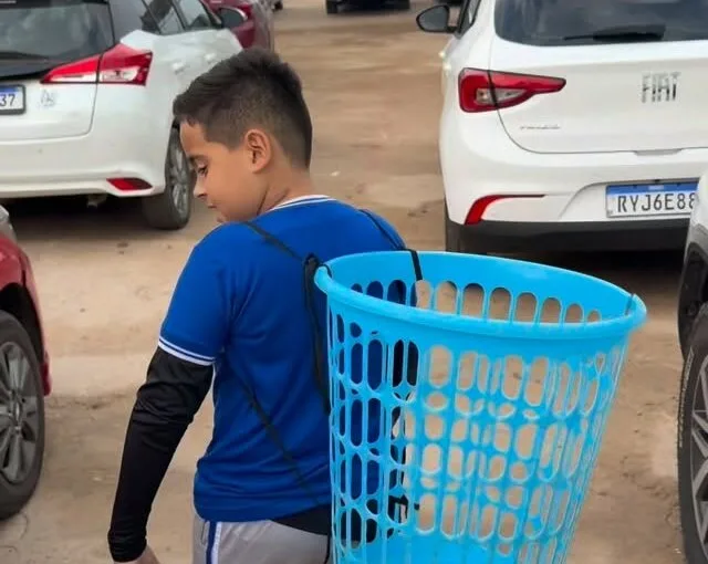 No Acre, menino vai à escola com cesto de roupa no dia da mochila maluca