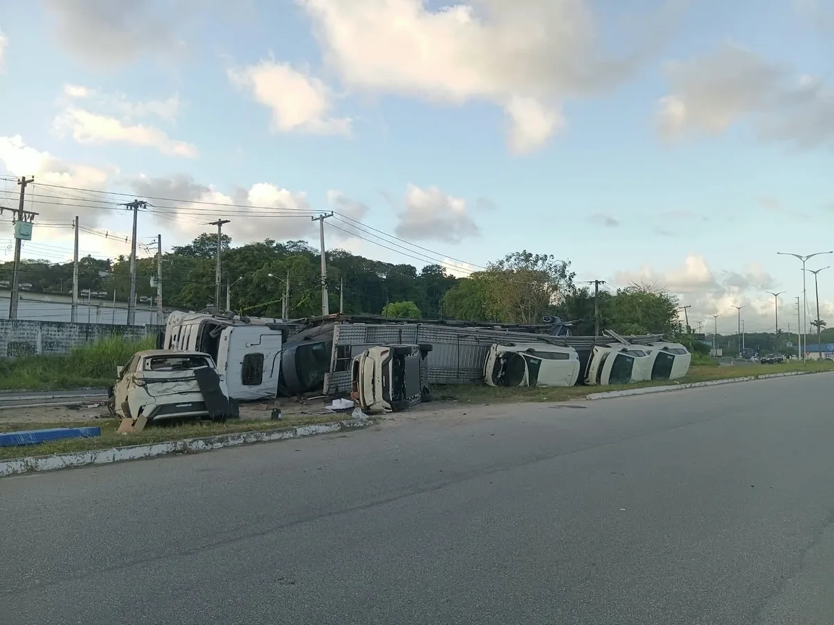 Caminhão-cegonha tomba e carros ficam espalhados no canteiro central; VÍDEO