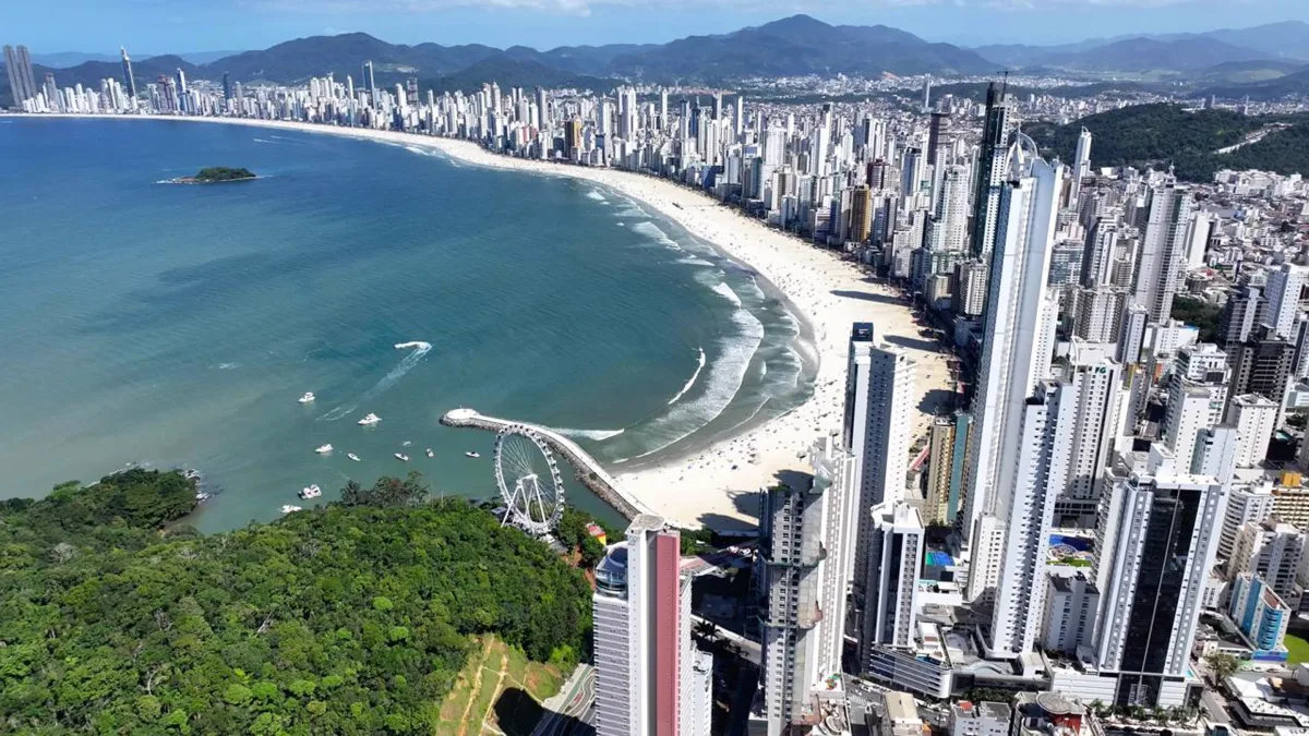 Cidade catarinense de prédios gigantes concentra praia de 7 km, comércio funcionando o ano inteiro e infraestrutura capaz de receber mais de 1 milhão de visitantes no verão