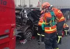 Carro com avós e neto fica destruído em batida que interdita a Dutra, em SP