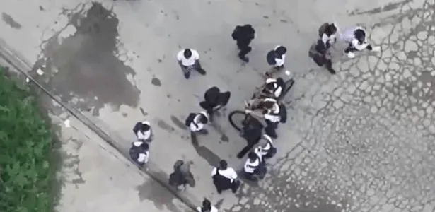 Drone da polícia flagra crianças ao redor de homem com fuzil no RJ