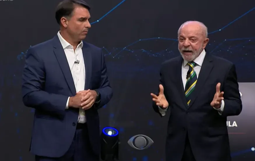Lula fala de Covid; Flávio admite falha, mas cita “pandemia de assassinato”