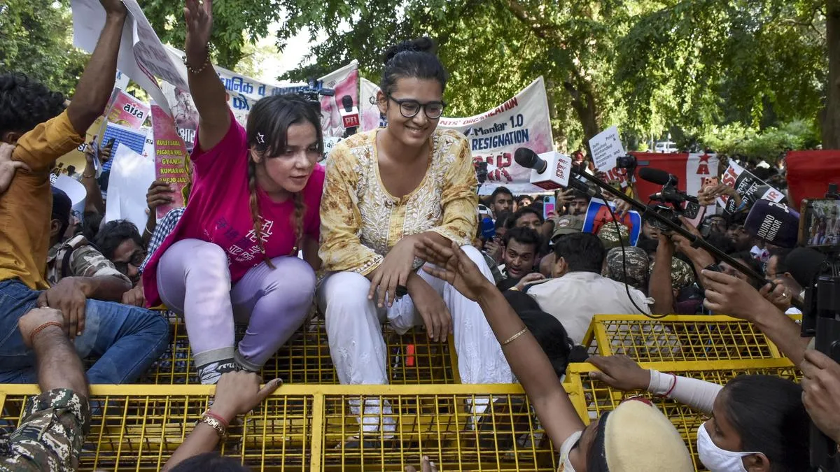 AISA chief Neha Bora climbs barricade during protest against CEC Gyanesh Kumar