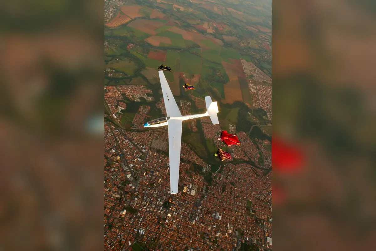 Paraquedistas voam em formação ao lado de planador e um deles chega a segurar na asa no interior de SP; vídeo