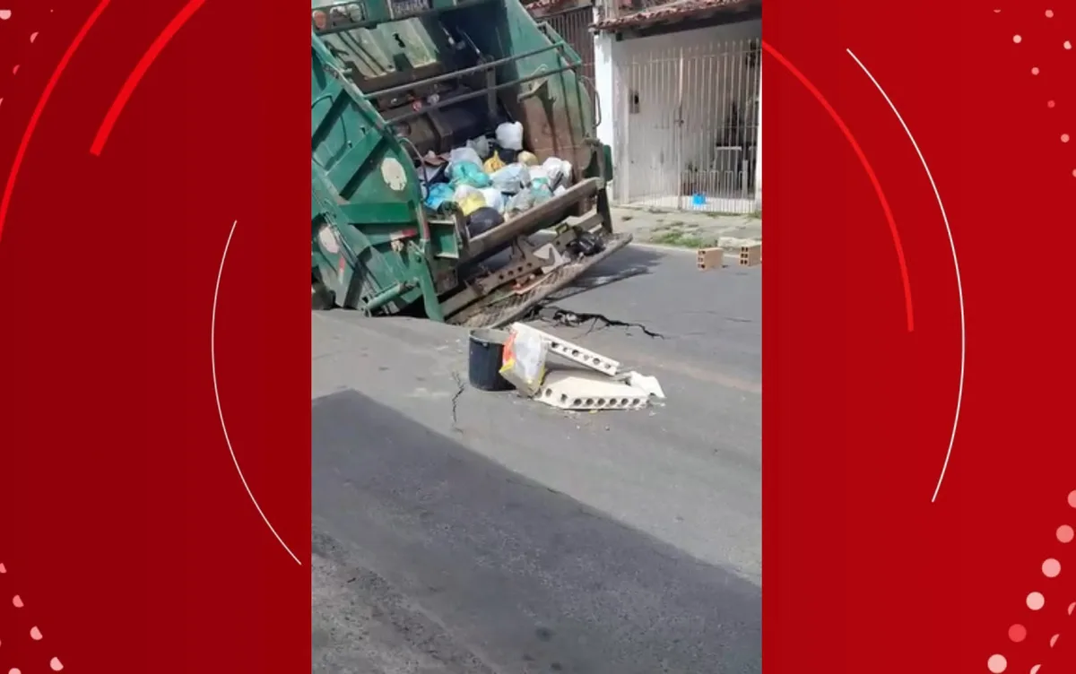 Caminhão de coleta de lixo fica preso após asfalto ceder em rua de Feira de Santana