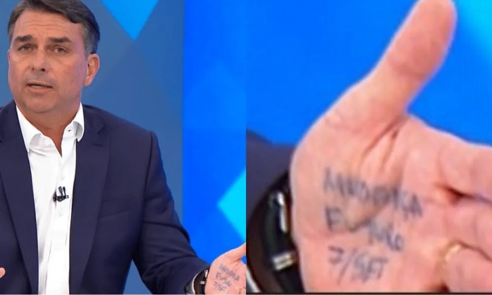 Flávio repete gesto de Jair Bolsonaro e leva cola na mão durante sabatina