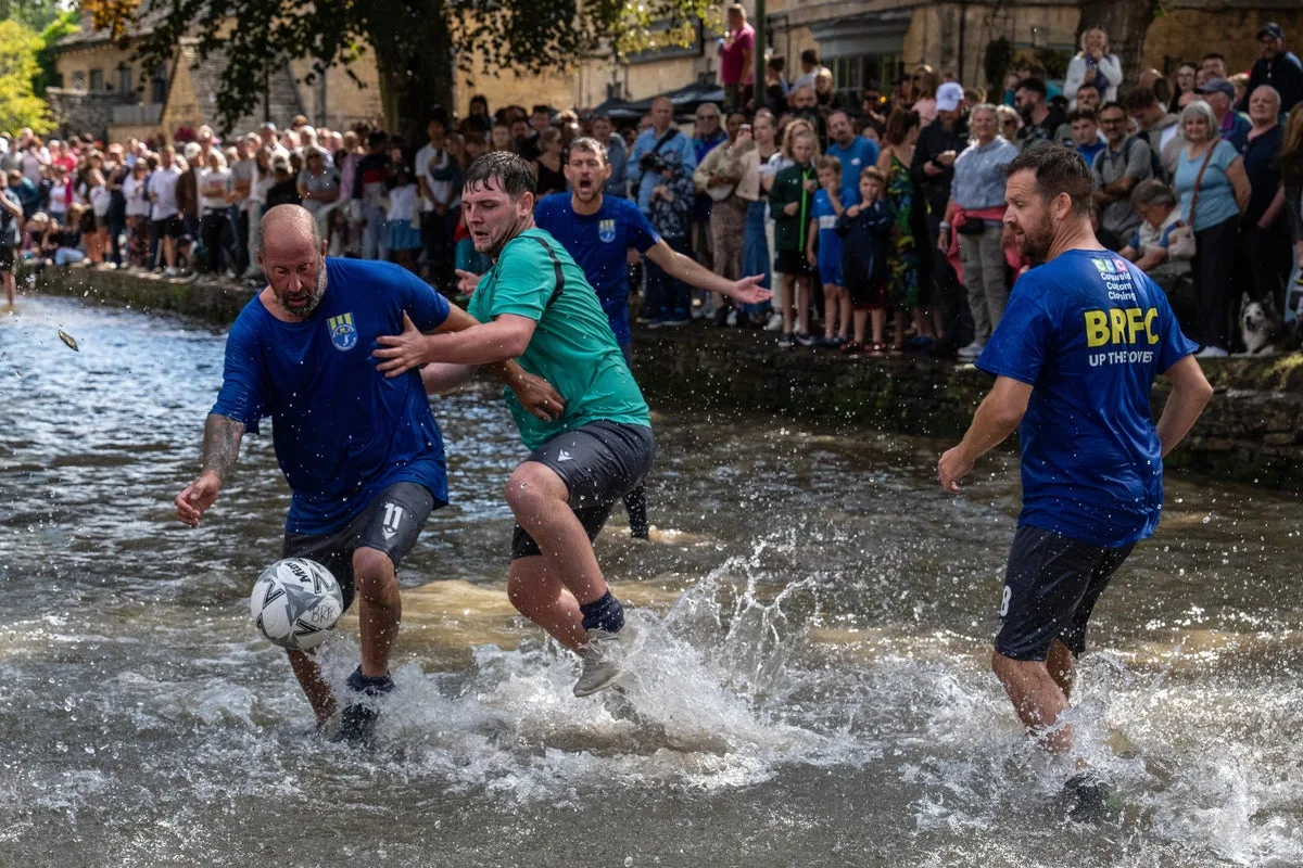 Hundreds flock to the Cotswolds village to watch bizarre football match in river