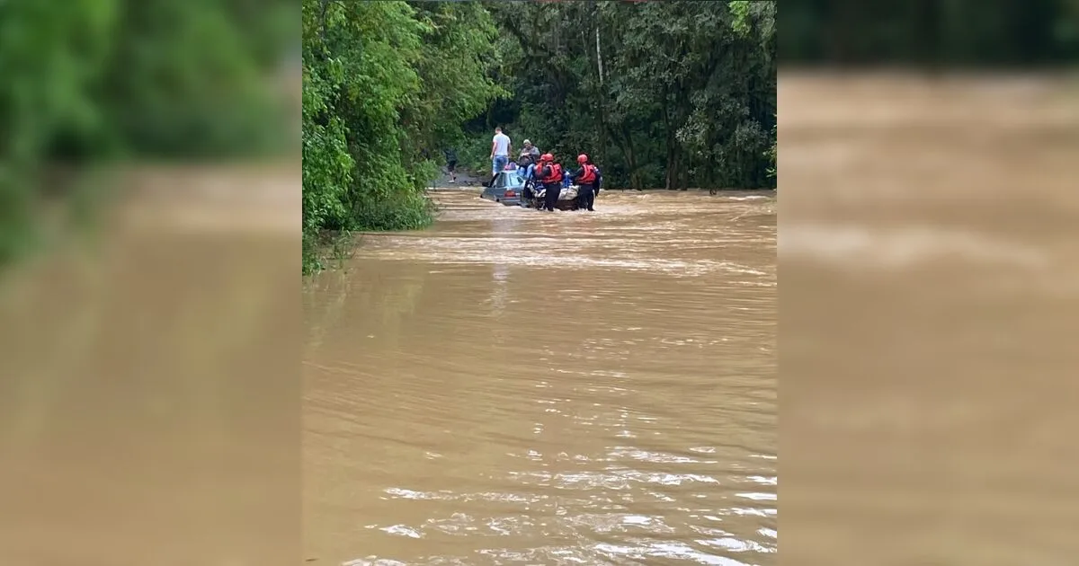 Família fica ilhada no teto de carro ao tentar cruzar estrada alagada no PR