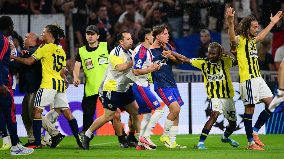 Escándalo en la Champions: un jugador del Fenerbahçe provocó con gestos obscenos y un hincha del Lyon lo atacó a patadas en el túnel