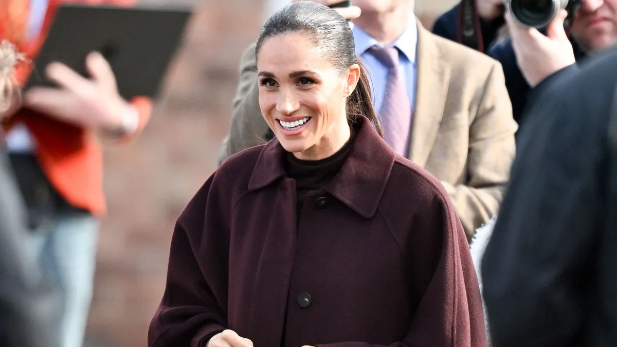 Meghan Markle, pura elegancia en su vuelta a Inglaterra con un look que resume las tendencias de otoño: tonos berenjena, falda midi y abrigo de manga ancha
