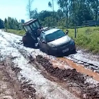 Estrada vira lamaçal e até trator fica preso ao tentar puxar carro em área rural