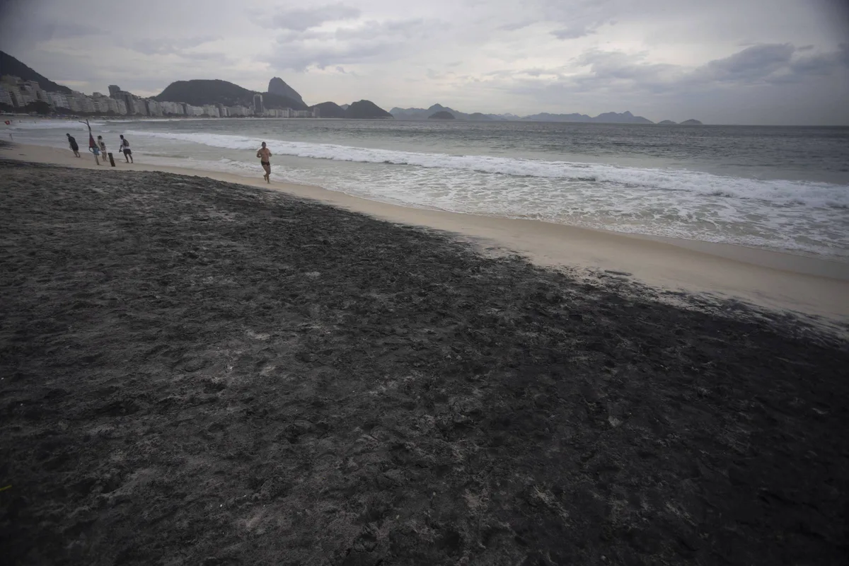 Areia escura toma trecho da praia de Copacabana