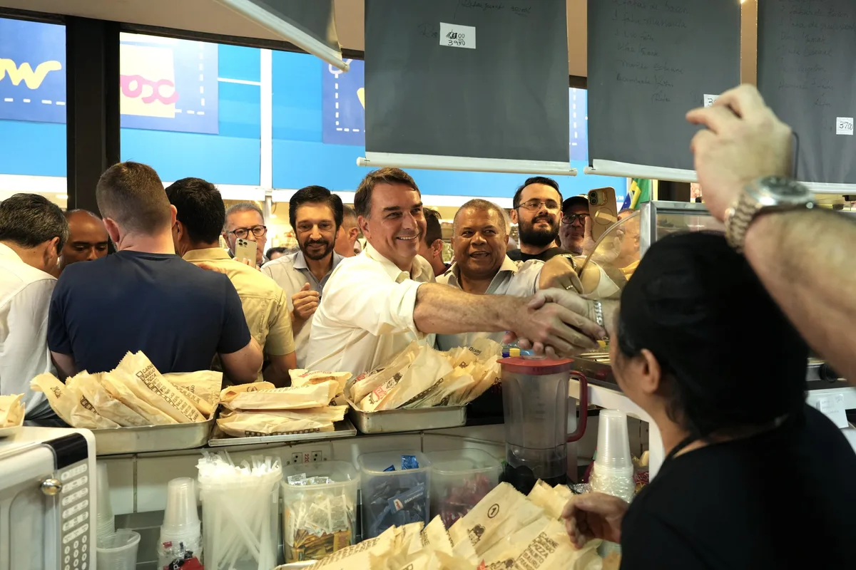 Flávio come pastel e promete “arrumar a bagunça” de Lula