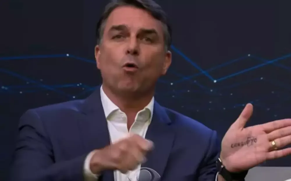 "CorruPTo": Flávio Bolsonaro faz cola na mão e provoca Lula no debate da Band
