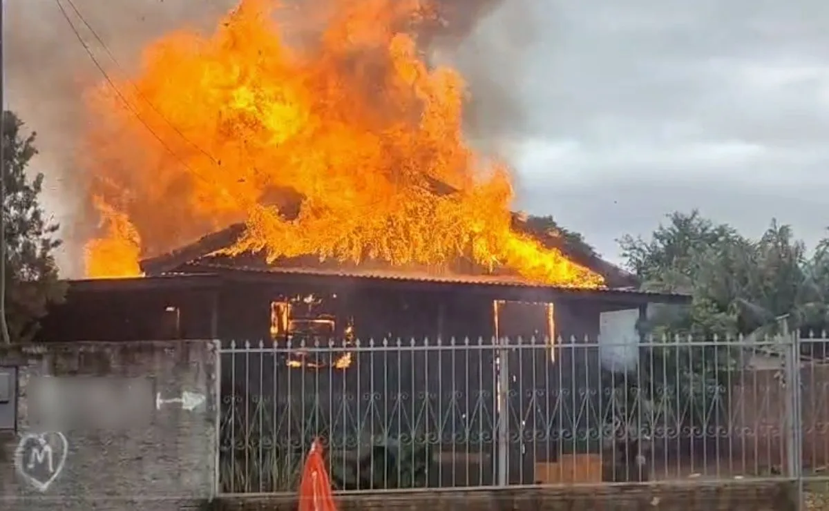 VÍDEO! Casa de madeira é destruída por fogo e vizinhos usam mangueiras para tentar salvar imóvel