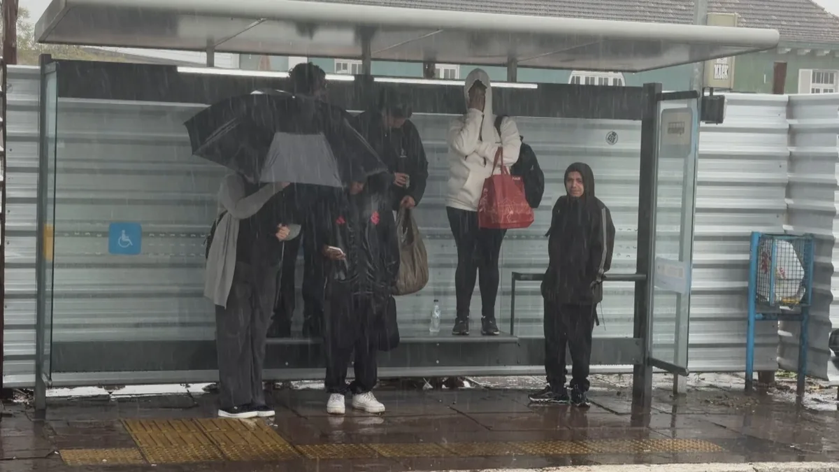 FOTO: passageiros sobem em banco para se proteger de chuvarada em parada de ônibus de Porto Alegre