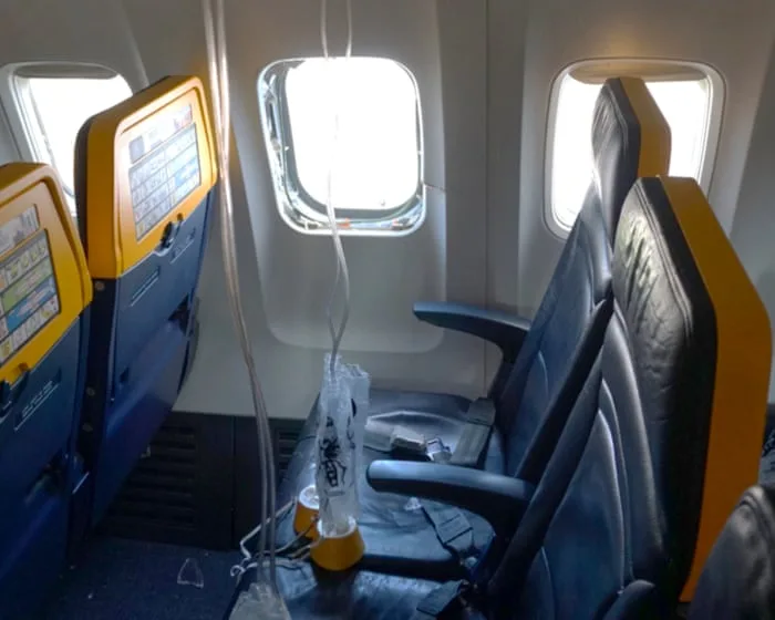 Engine parts shattered Ryanair window that passenger was partly sucked out of, report says