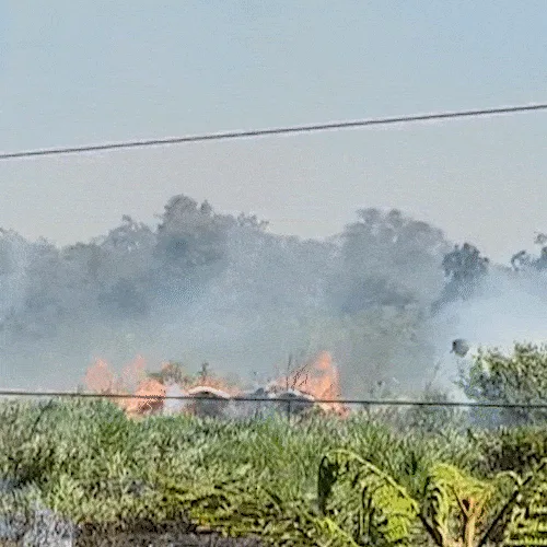 Cena corriqueira atualmente, incêndio em terreno é combatido com baldes de água