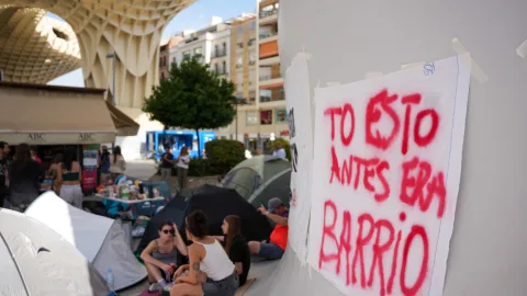 La acampada de la vivienda en Sevilla celebra su Día de la Hispanidad a ritmo del himno de Andalucía y contra la especulación inmobiliaria
