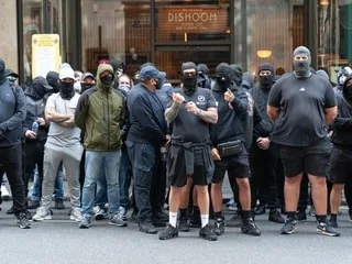 Royaume-Uni : masqués et habillés de noir, des militants d’extrême droite britanniques traquent les migrants