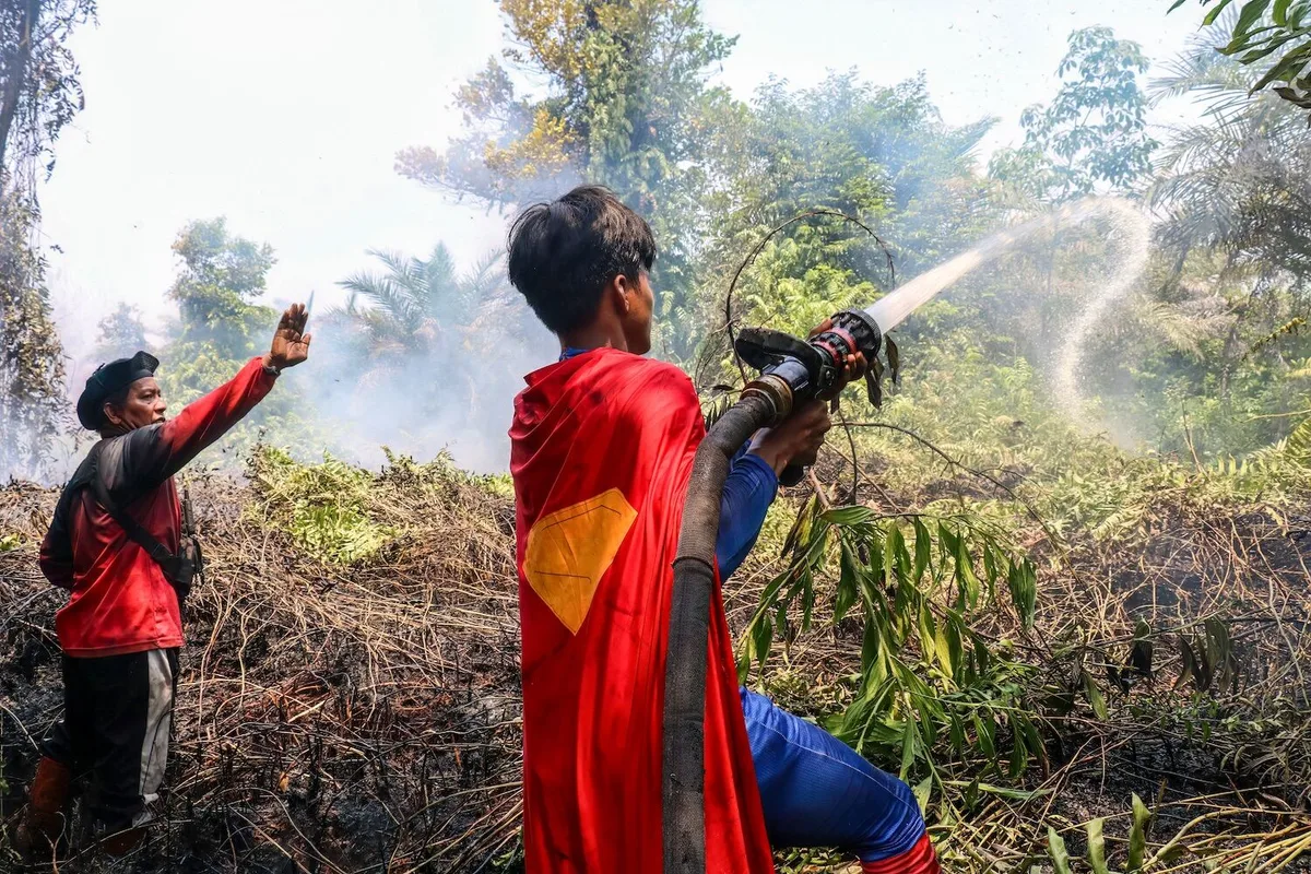 “Herói da floresta”. Adolescente de capa vermelha combate incêndios na Indonésia