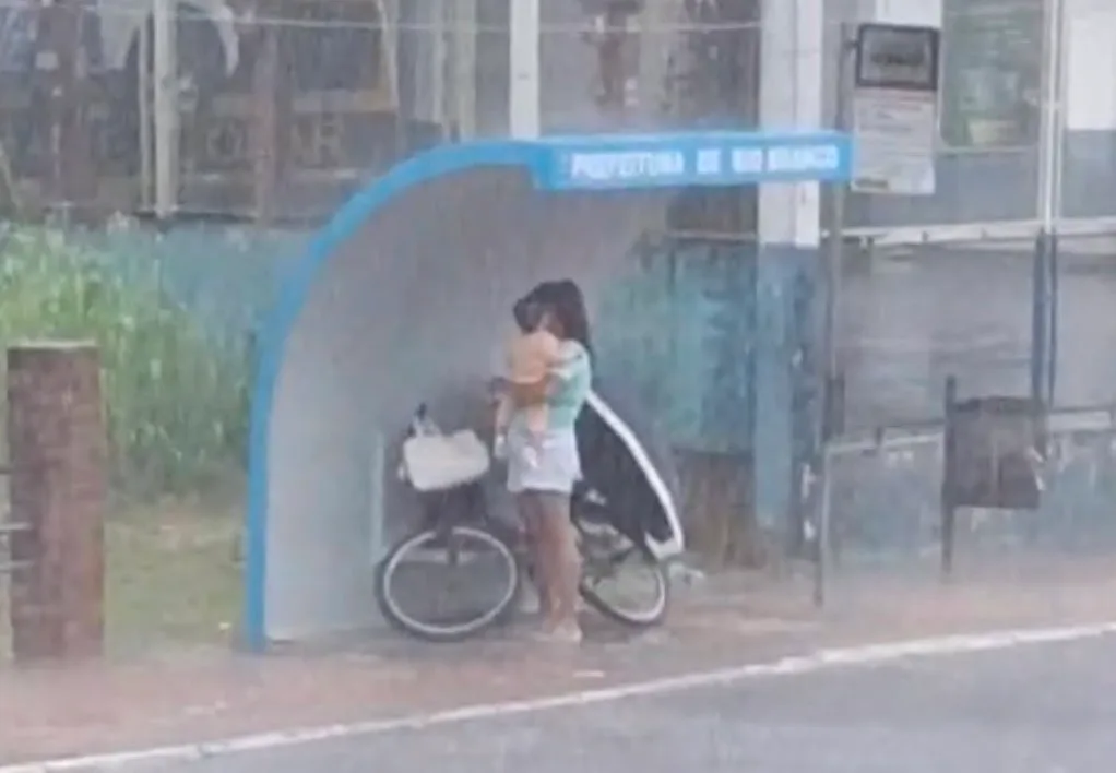 Mãe usa parada de ônibus para proteger bebê da chuva em Rio Branco
