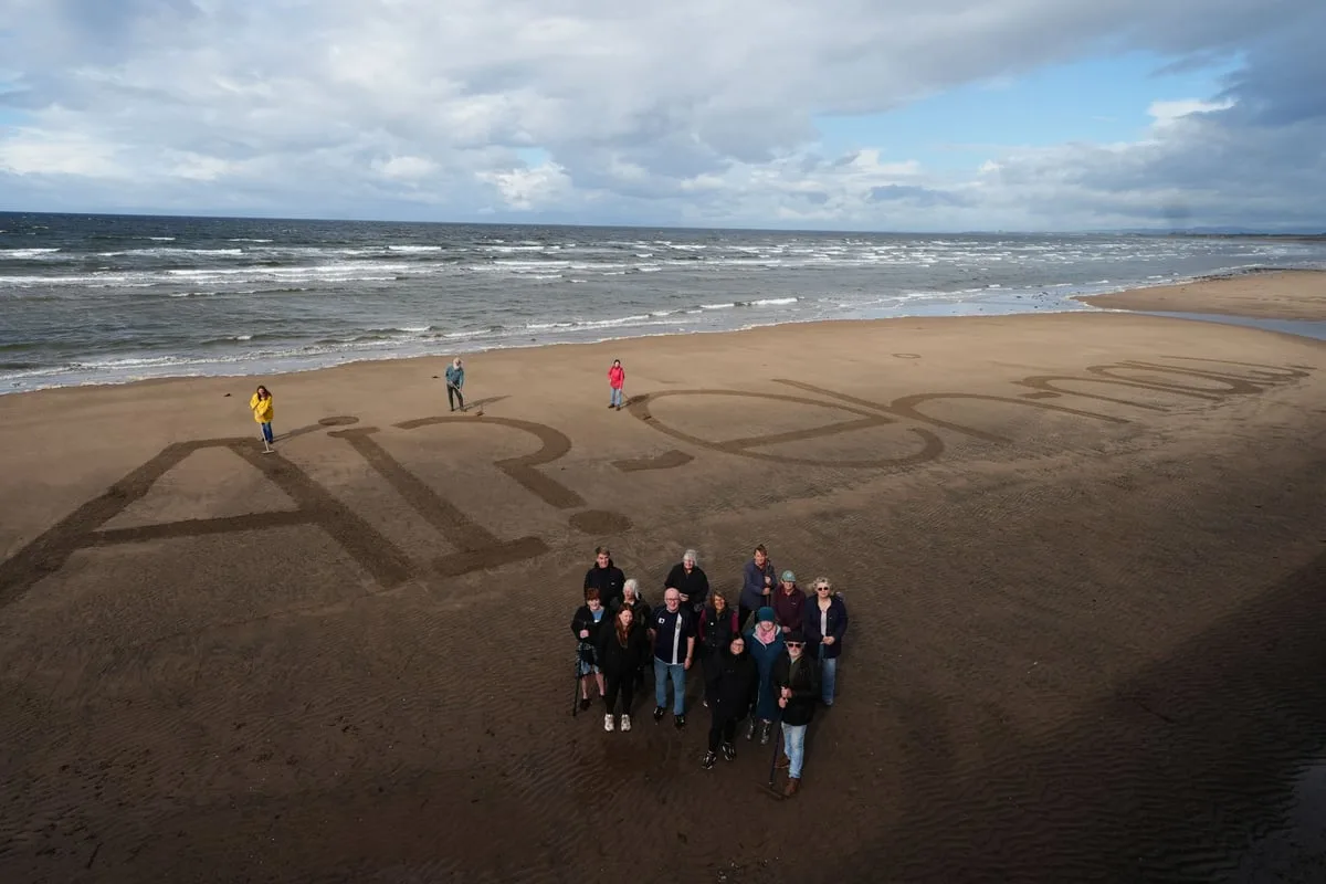 Activists write ‘naw’ to AI on beach as execs set to fly in for summit with King