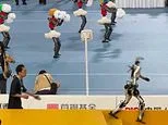 Robots, they're just like us! Watch the hilarious moment a humanoid falls down the stairs after getting distracted by a crowd of cheerleaders