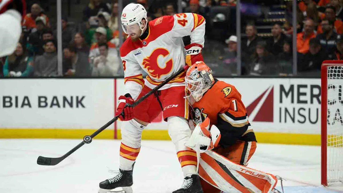 Flames break tie late, beat Ducks for first win