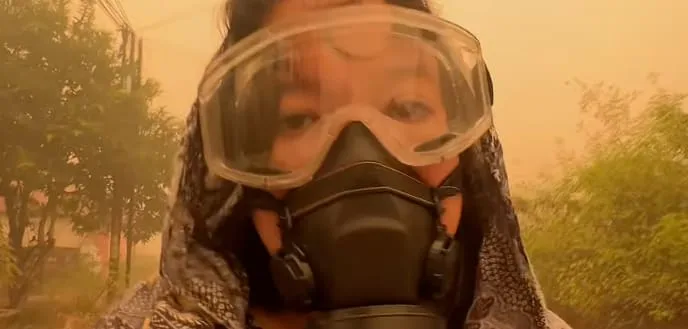 „Nirgendwohin kann man fliehen“, sagt die Frau mit der Gasmaske vor dem gelben Himmel