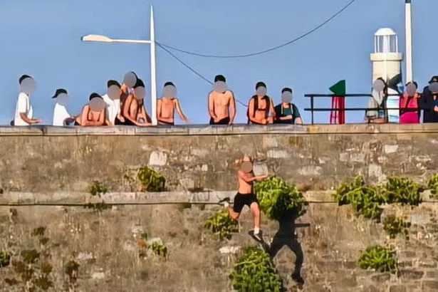 Youngsters seen tombstoning from dangerous 65ft cliff known as 'Dead Man's Cove' where dad plunged to death