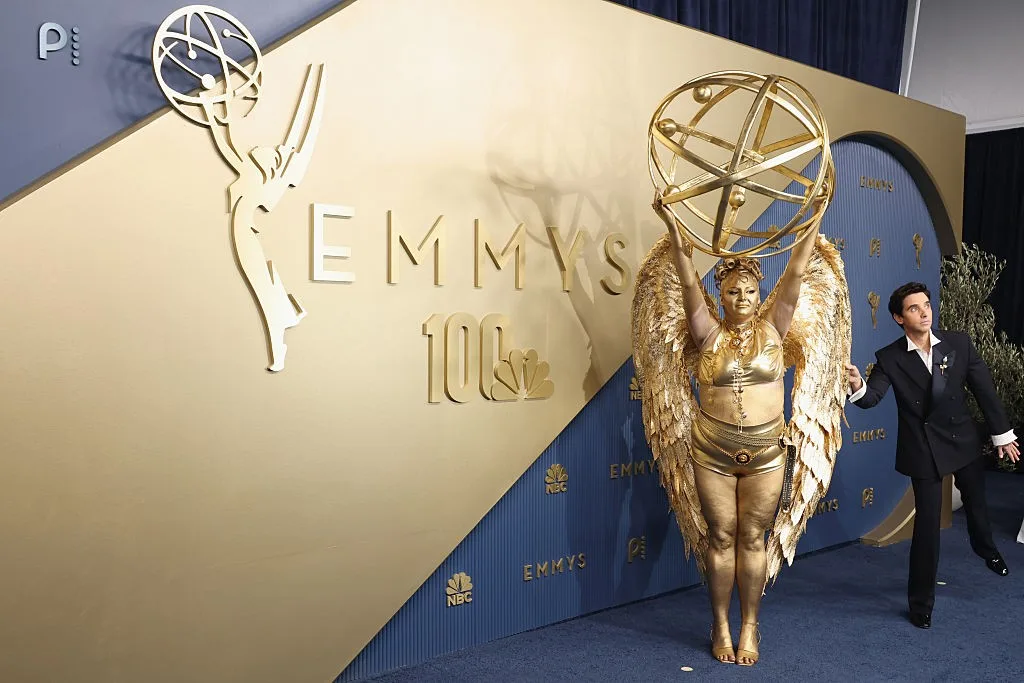 Atriz de Hacks rouba a cena no tapete vermelho Emmy com figurino de estatueta